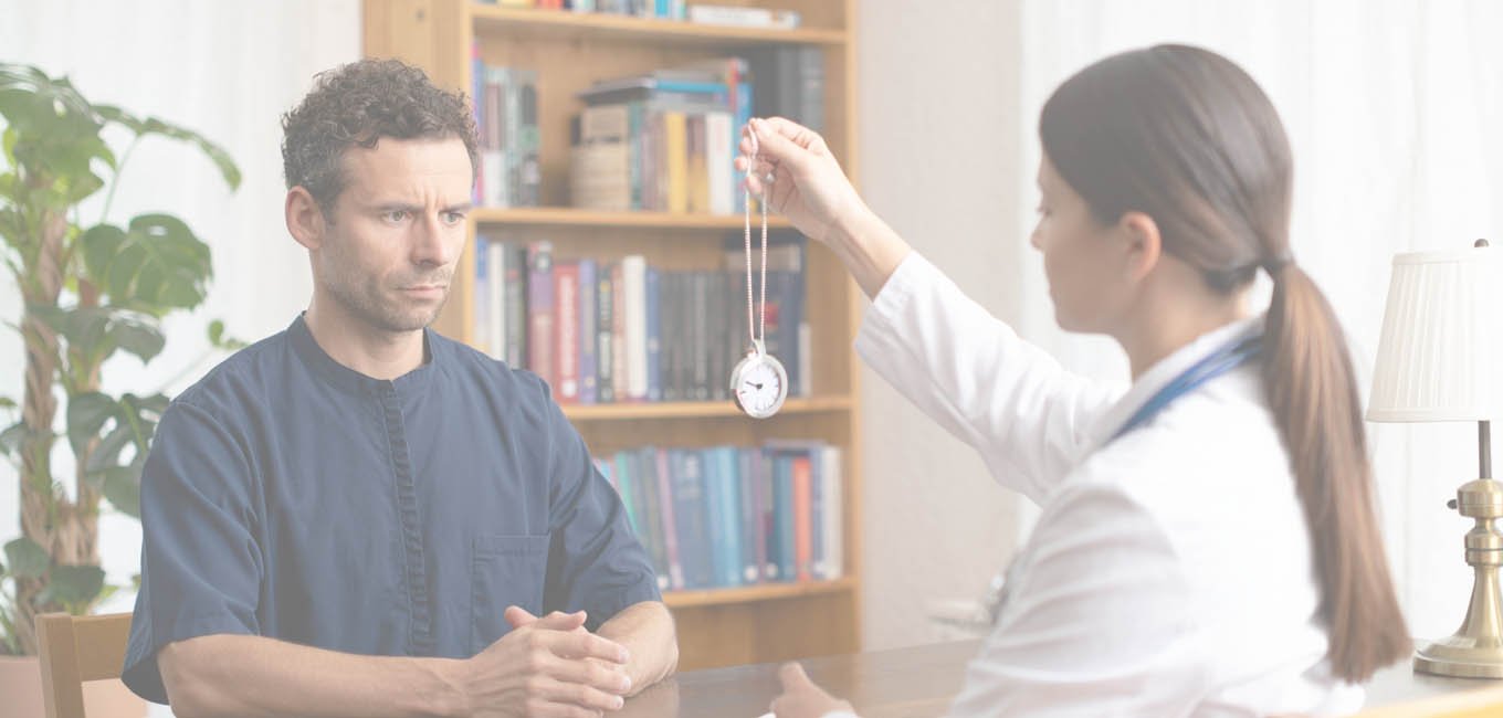 Мужчина-пациент сидит в кресле на гипнотерапии